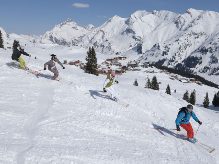Die atemberaubende Winterlandschaft des Arlbergs Skifahrer fahren die Piste hinunter